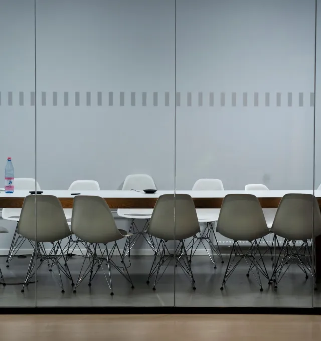 boardroom table with 12 white chairs