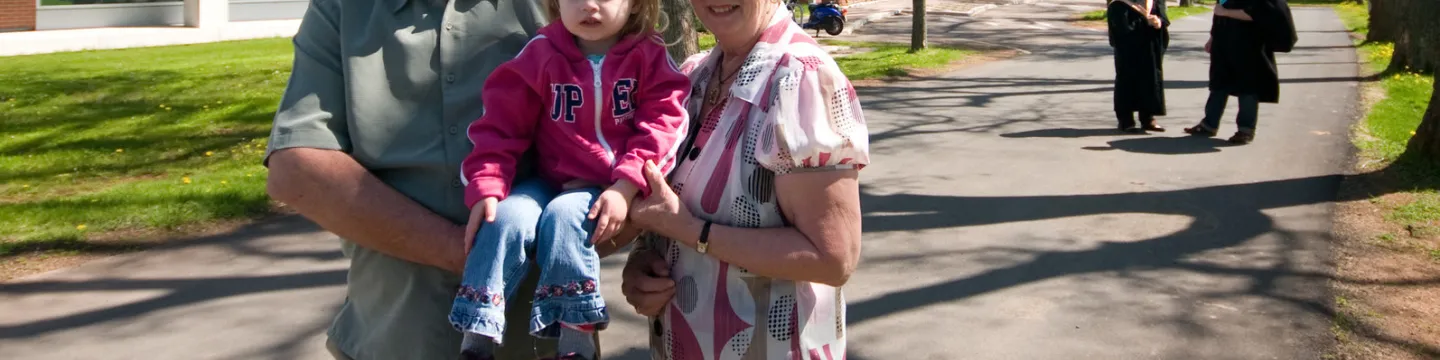 Donors stand with their granddaughter on campus