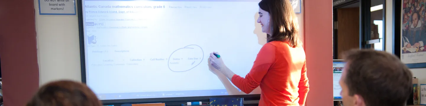 A woman writes on a smart board