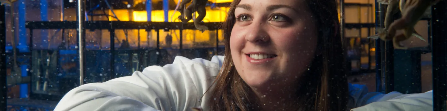 biologist with frog in a tank