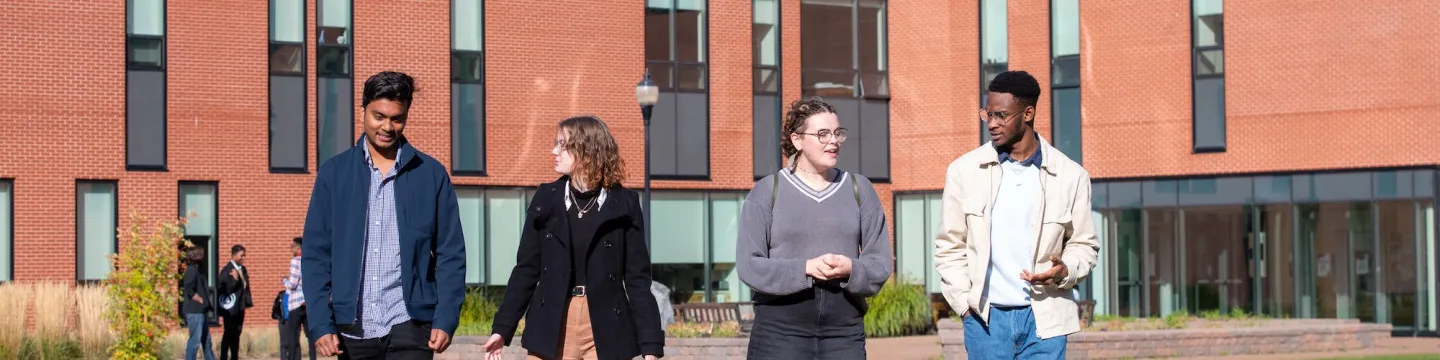 students walking in front of the brick Health Sciences Building