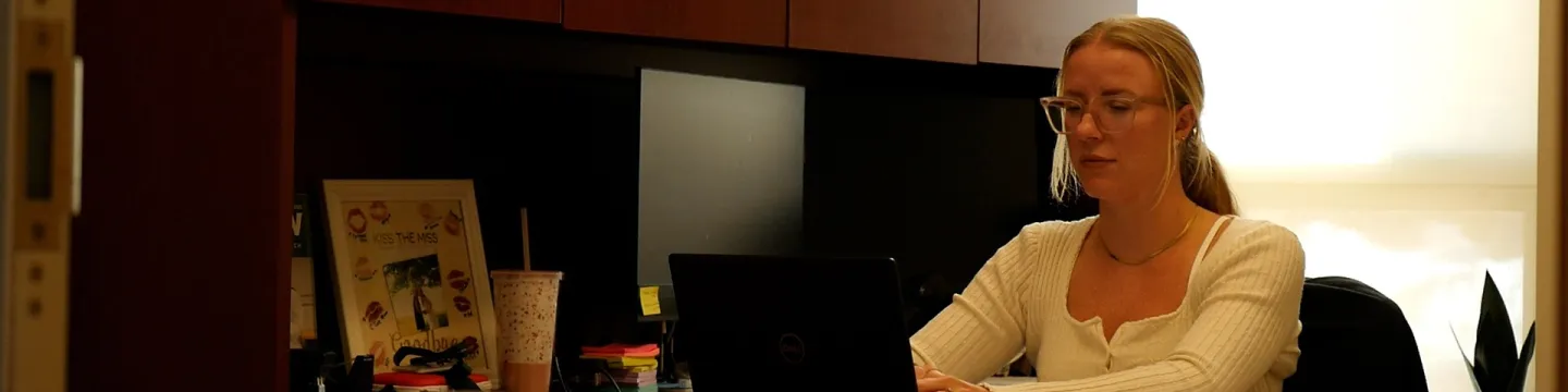UPEI assistant professor Ashton Dougan in her office on a computer