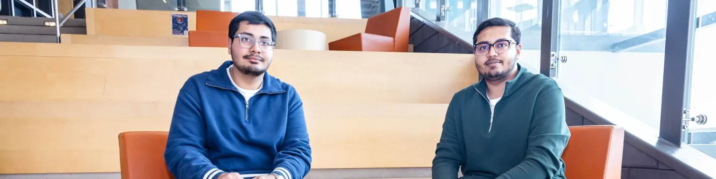 UPEI engineering students Syed Imran Ali and Syed Daniyal Ali sitting in a lit building atrium