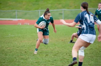 a UPEI rugby player running with a ball