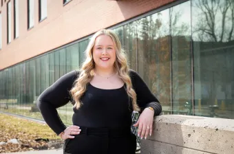 UPEI nursing student Kayla MacLeod reading a book in the foyer of the Health Sciences Building